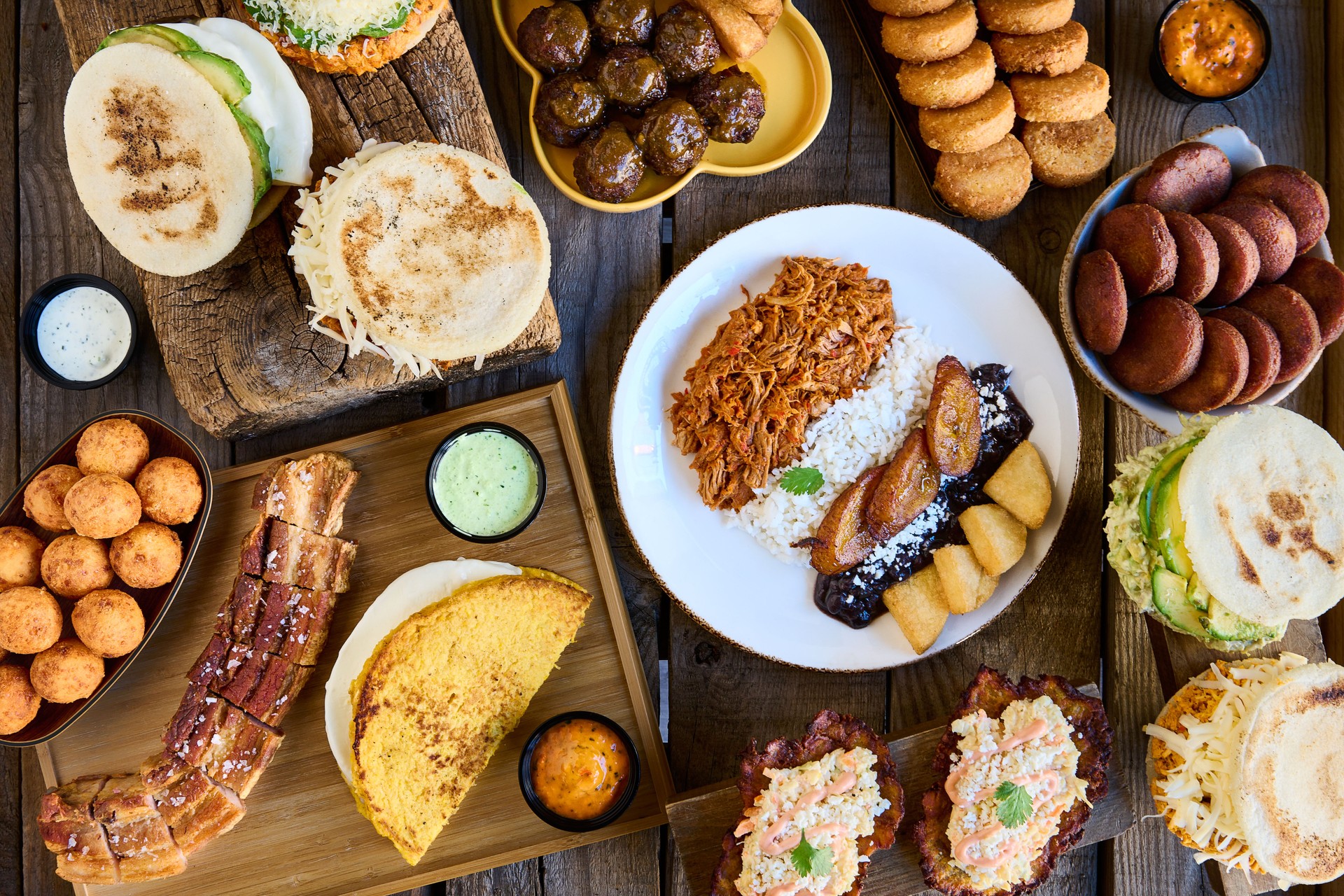 Table with typical Venezuelan food. Creole pavilion, arepas, fried pork and stuffed empanadas